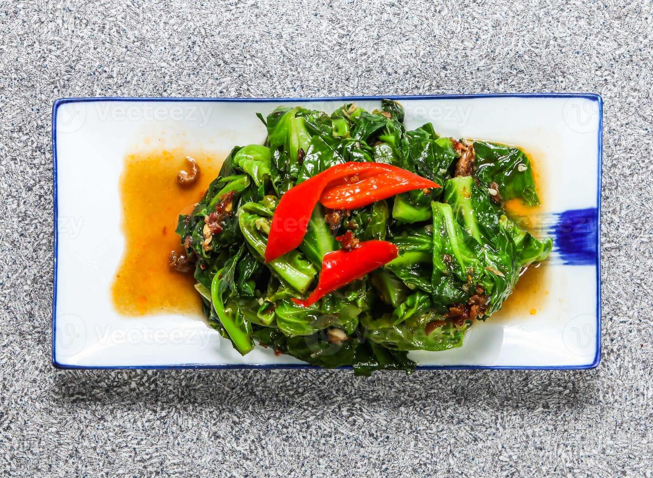 thai fried thai cabbage with belacan, kale and red pepper served in tray dish isolated on grey background top view hong kong healthy green food photo