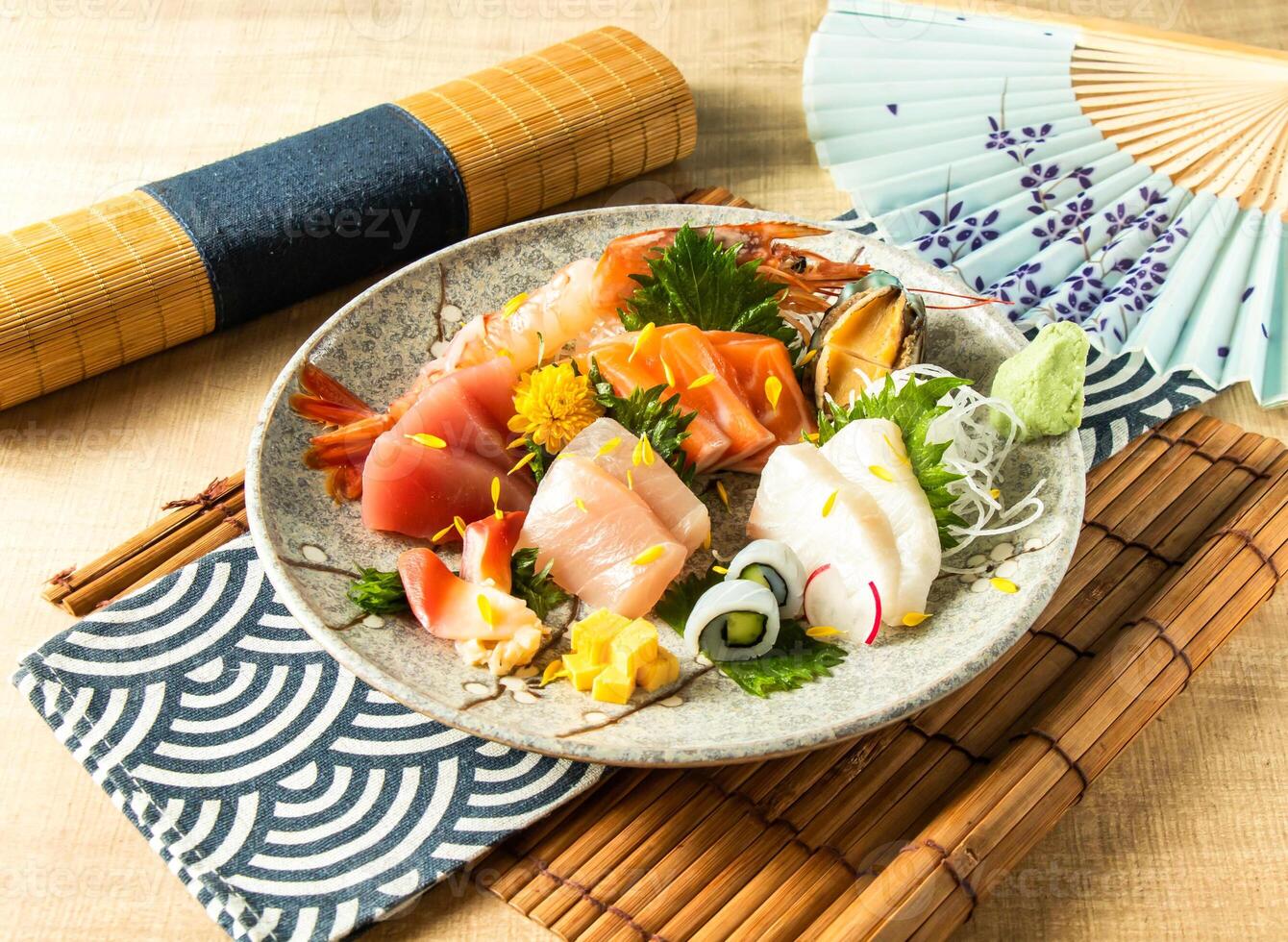 Assorted Comprehensive Sashimi with Dory sashimi, salmon sashimi, Tuna fish, swordfish served in plate isolated on napkin side view on wooden background of Japanese food photo
