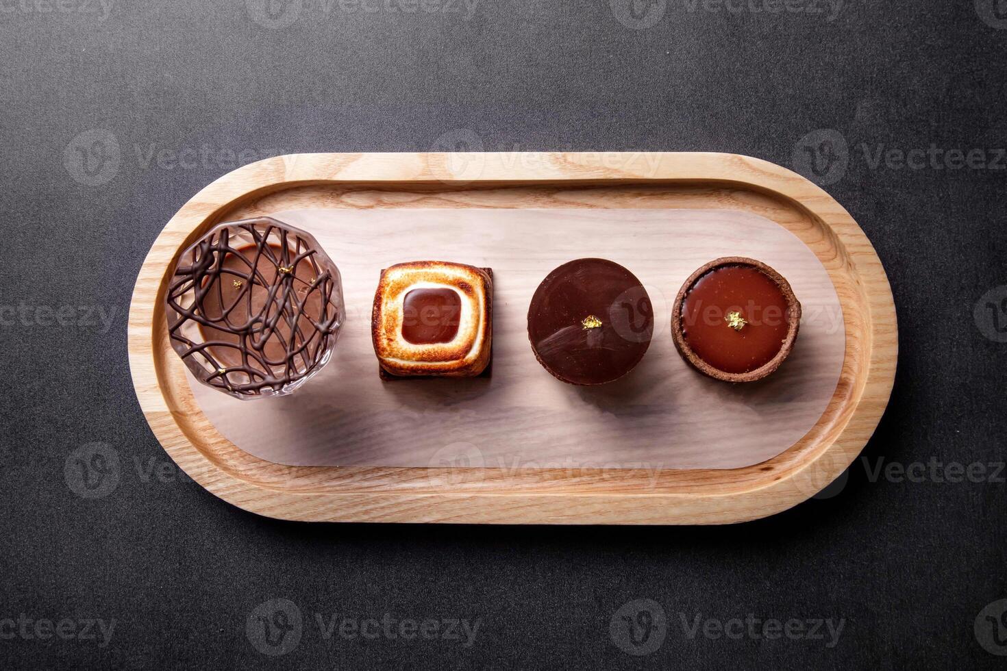 Single Origin Chocolate Flight Toasted Marshmallow Chocolate Tart, cacao Chocolate Puff balls, Chocolate Tart round, with fork served in dish isolated on dark background top view of baked cafe food photo