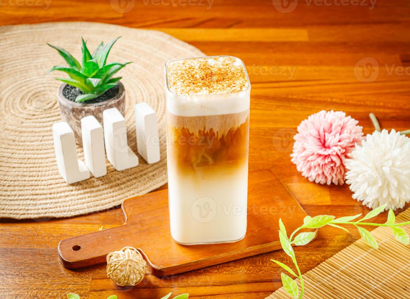 Brown Sugar iced Latte served in glass isolated on wooden table side view of Taiwan drink photo