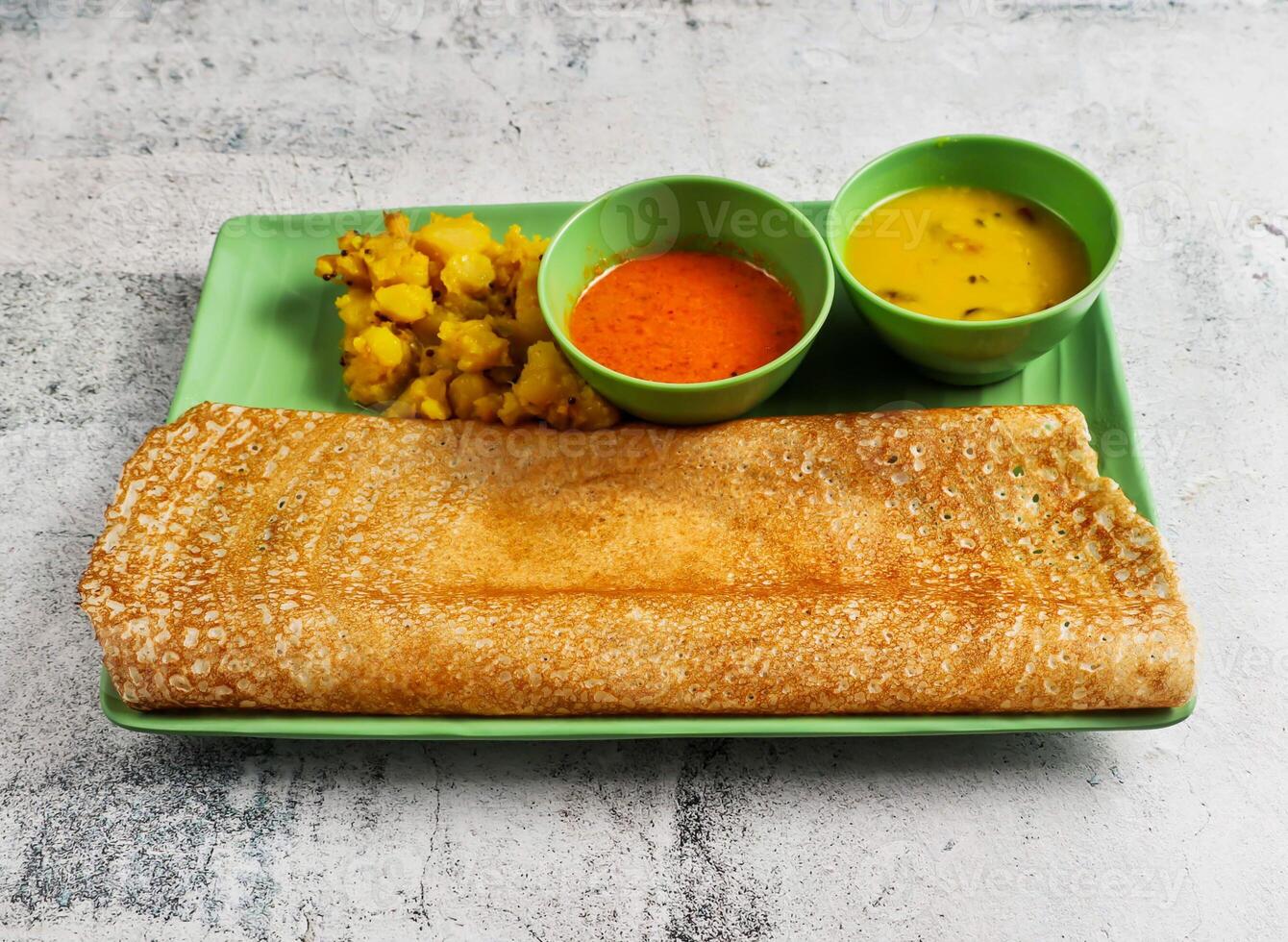 masala thosai or masala dosa with gravy sauce and potato bhujia served in dish isolated on grey background side view of singapore food photo