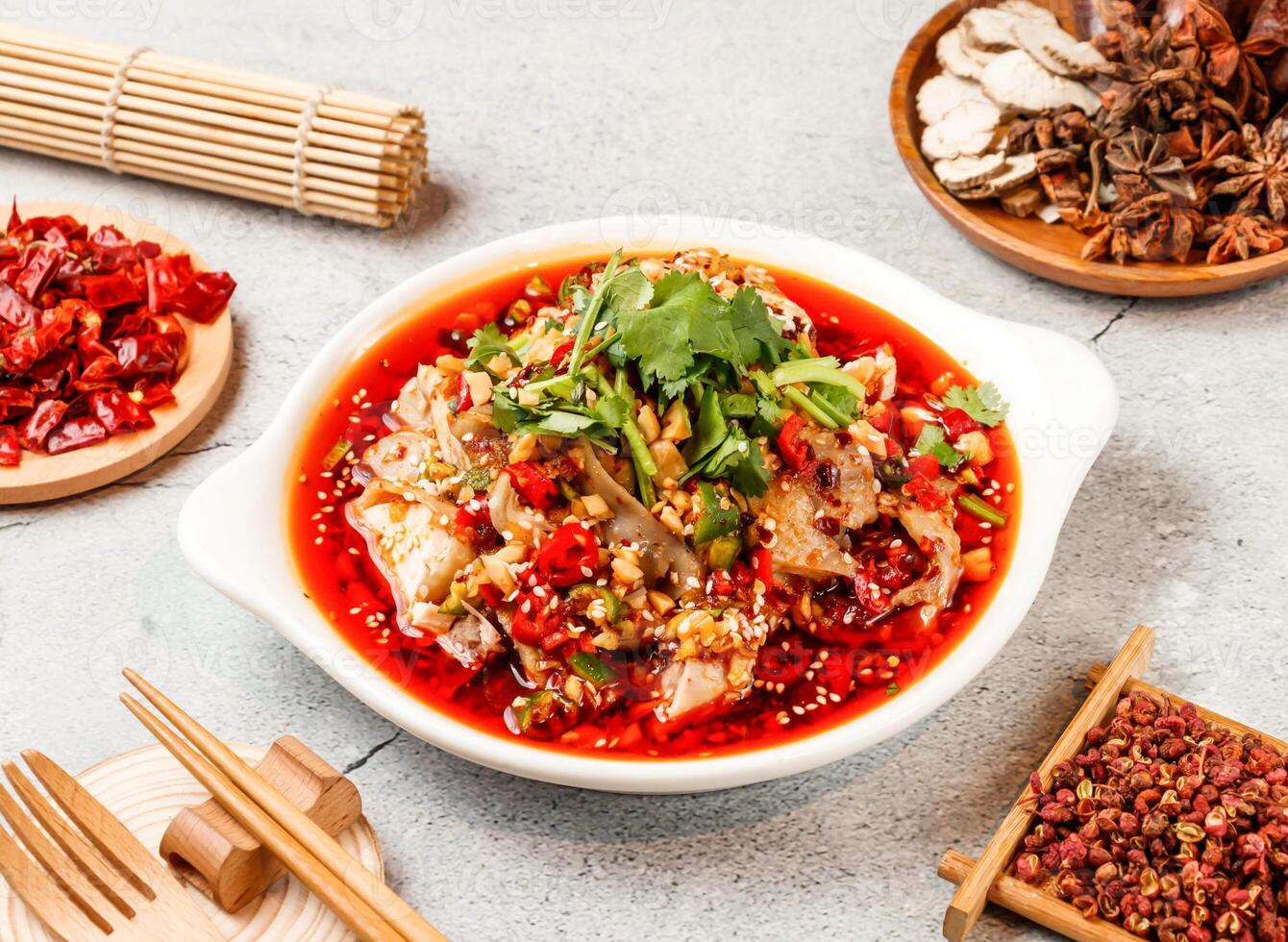 Spicy Saliva chicken with red chilli, chopsticks and fork served in pot isolated on background side view of taiwanese food photo