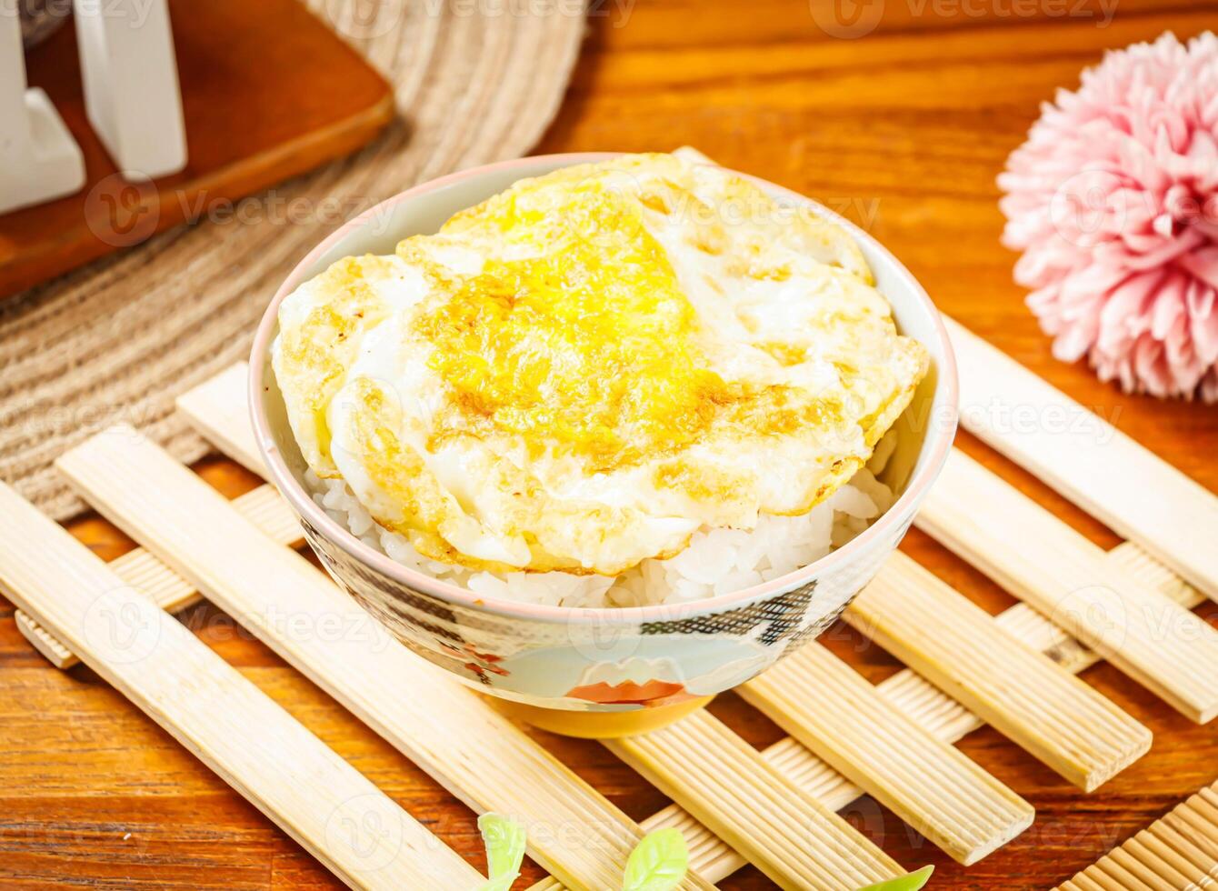 white rice with egg omelet served in dish isolated on wooden table side view of taiwan food photo