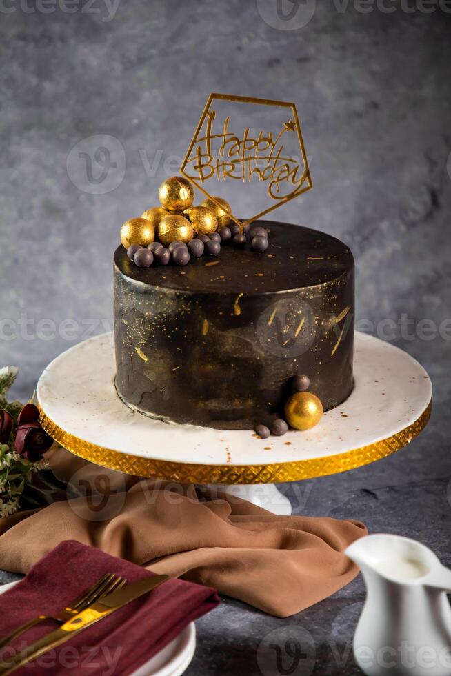 Happy Birthday chocolate Cake with choco balls, fork and knife served in stand isolated on napkin side view of cafe baked food photo