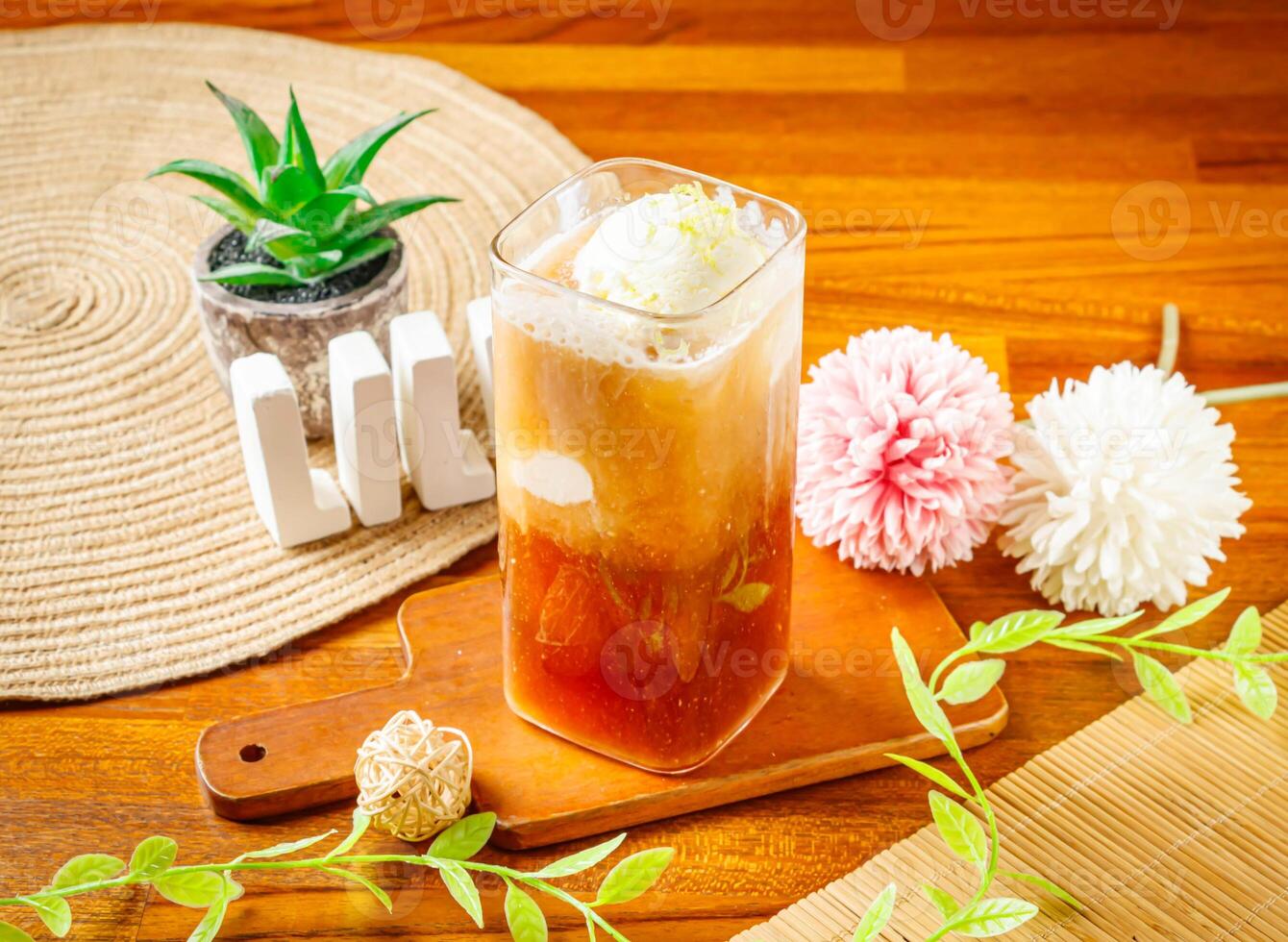 Ice cream black tea served in glass isolated on wooden table side view of Taiwan drink photo