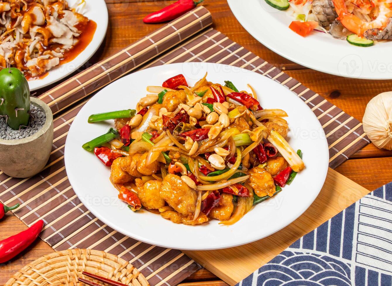 Kung Pao Chicken noodles with peanuts, spring onion red pepper and chopsticks served in dish isolated on table side view taiwanese food photo
