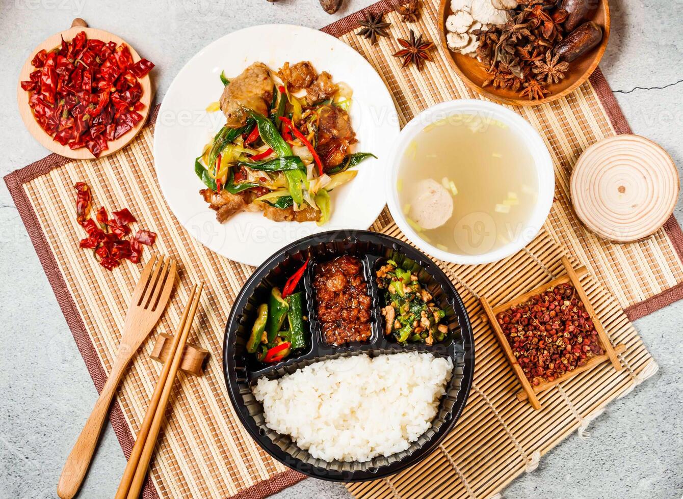 twice cooked pork, mice meat, white rice, soup with red chilli, chopsticks and fork served in pot isolated on background side view of taiwanese food photo