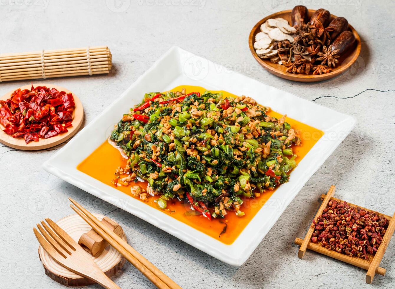 Snow red minced meat with red chilli, chopsticks and fork served in pot isolated on background side view of taiwanese food photo