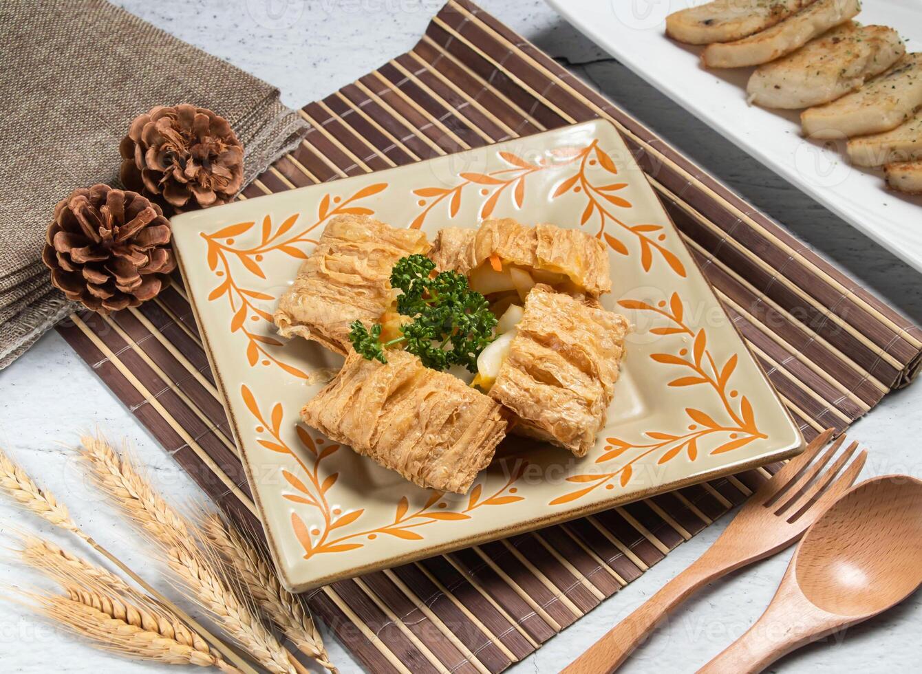 beancurd tofu gold with wheat, spoon and fork served in dish isolated on napkin side view of taiwanese food photo