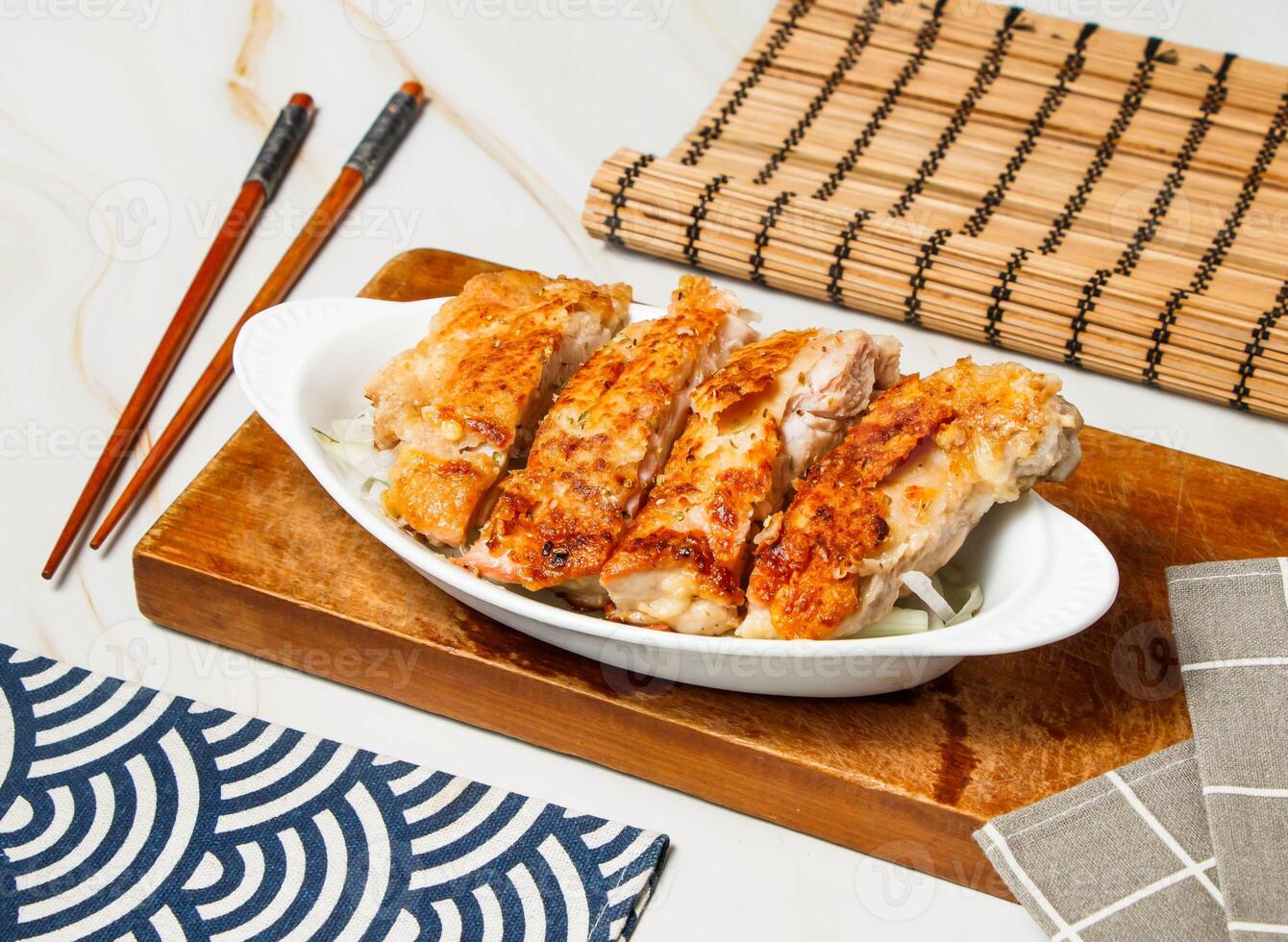 Italian Chicken Leg Steak Slice with chopsticks served in dish isolated on wooden board and napkin side view of taiwan food photo