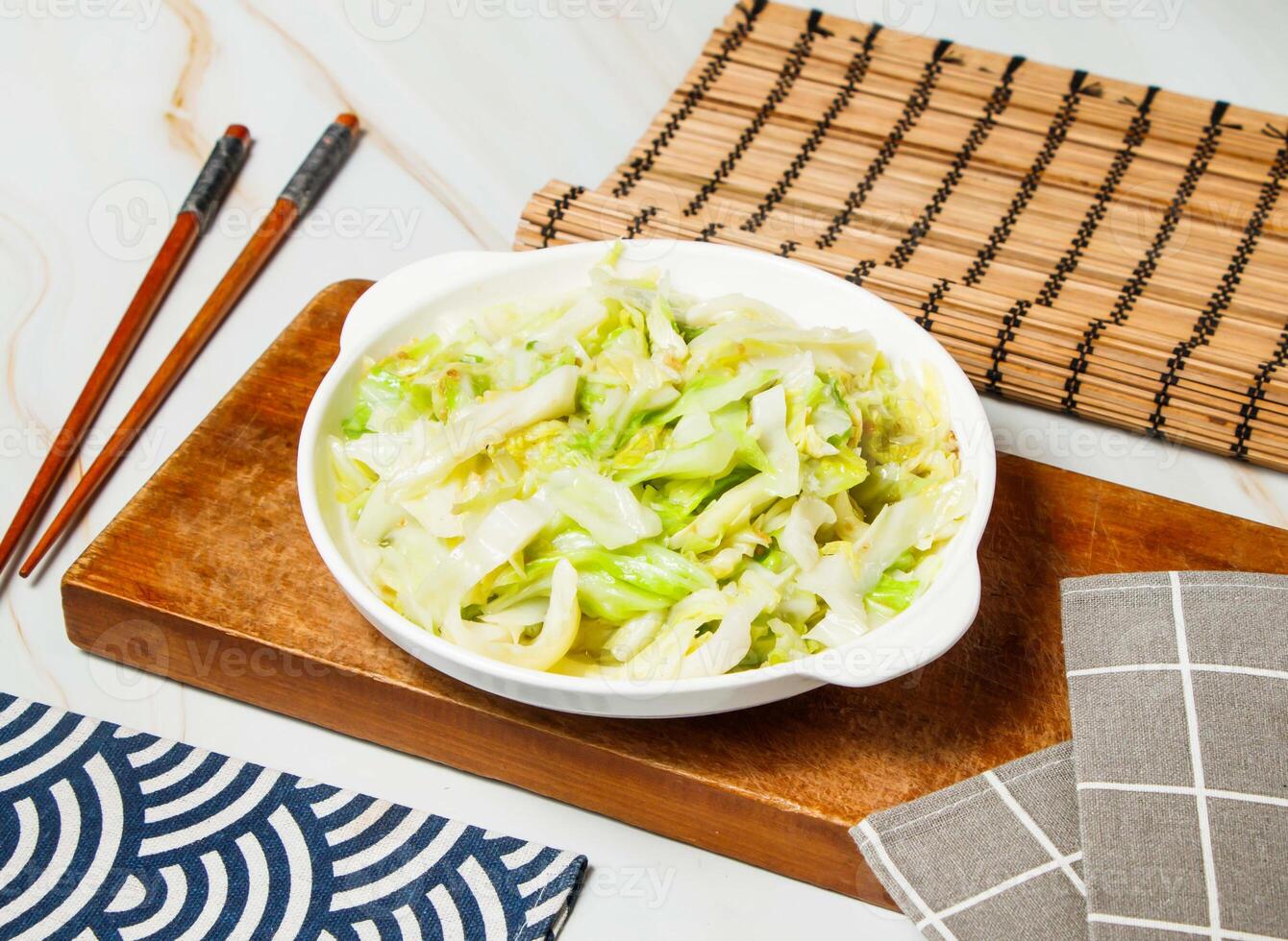cabbage salad with chopsticks served in dish isolated on wooden board and napkin side view of taiwan food photo