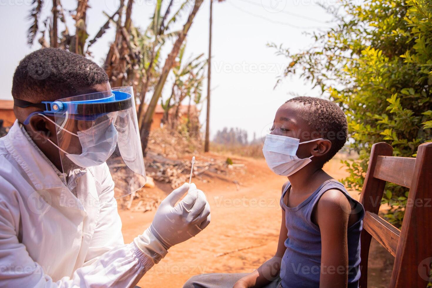 A doctor holding a swab to perform a molecular test on a child in Africa photo