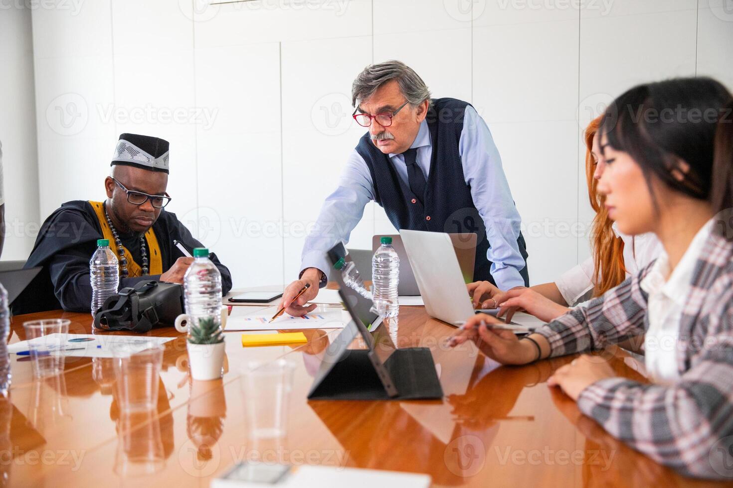 Work meeting in a corporate, the boss explains the work to the employees, multi ethnic group photo