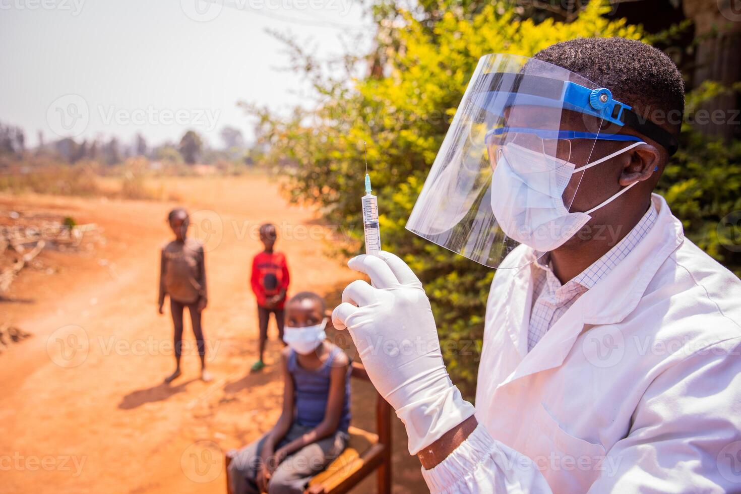 An African doctor is about to vaccinate children to prevent coronavirus infection. Vaccination concept in africa photo