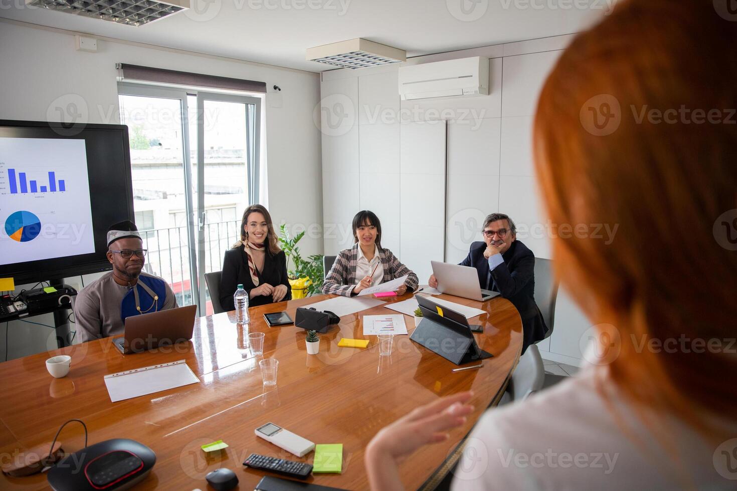 Business woman talking to her business partners at a meeting, multi ethnic group photo