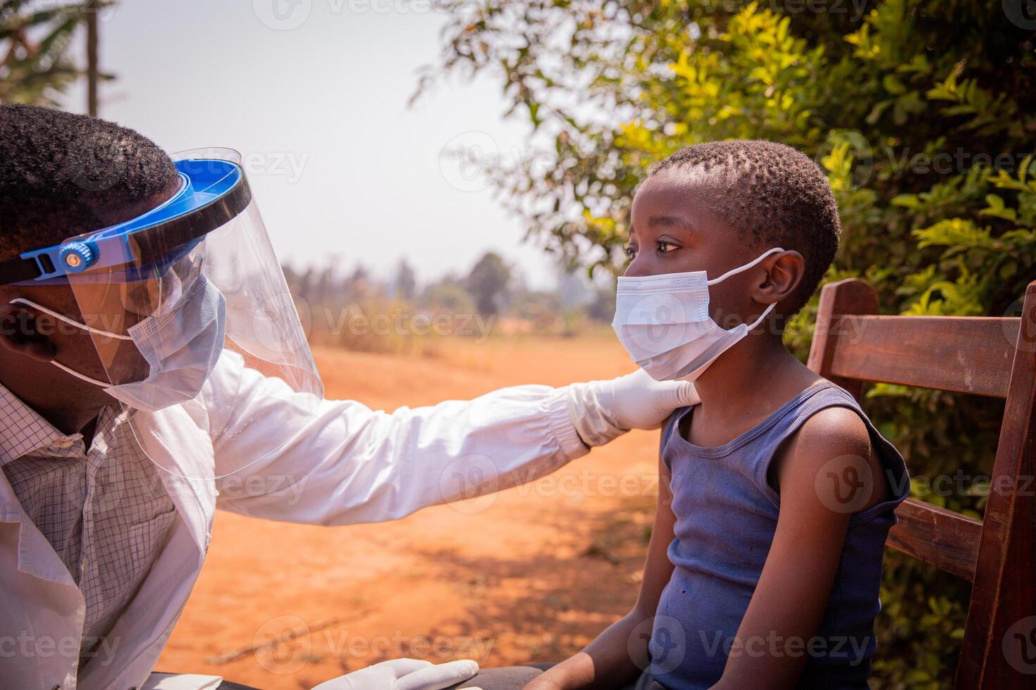 African doctor is busy visiting a young child who is about to take a serological test photo