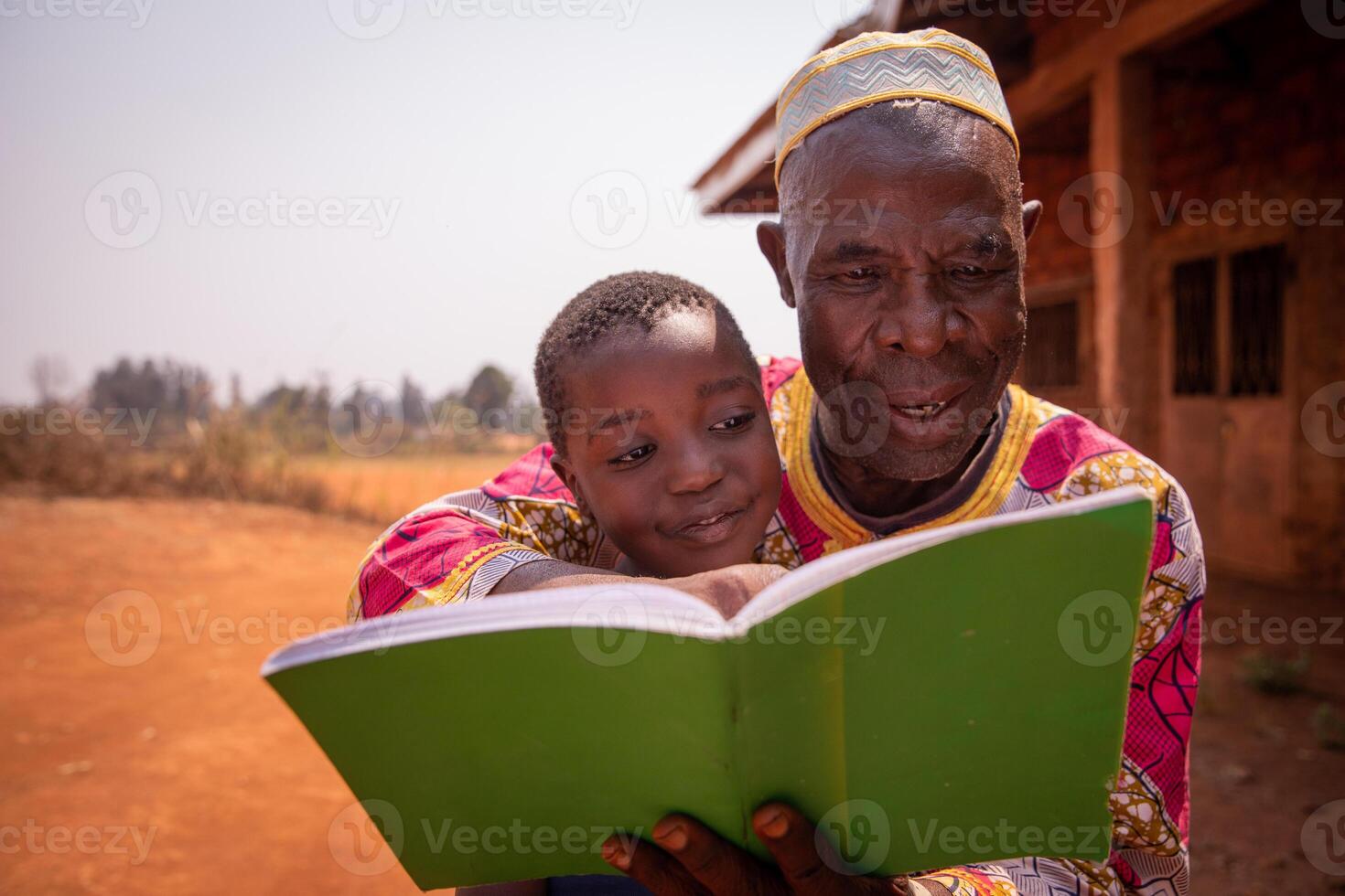 African grandfather reads a book with his grandson, moment of love and tenderness between them. Concept of grandfather educating his grandson. photo
