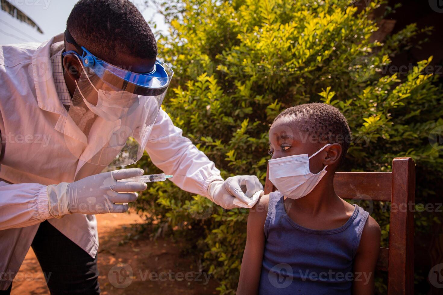 A doctor in africa vaccinates a child. Doctor injects coronavirus vaccine to a kid in Africa. photo