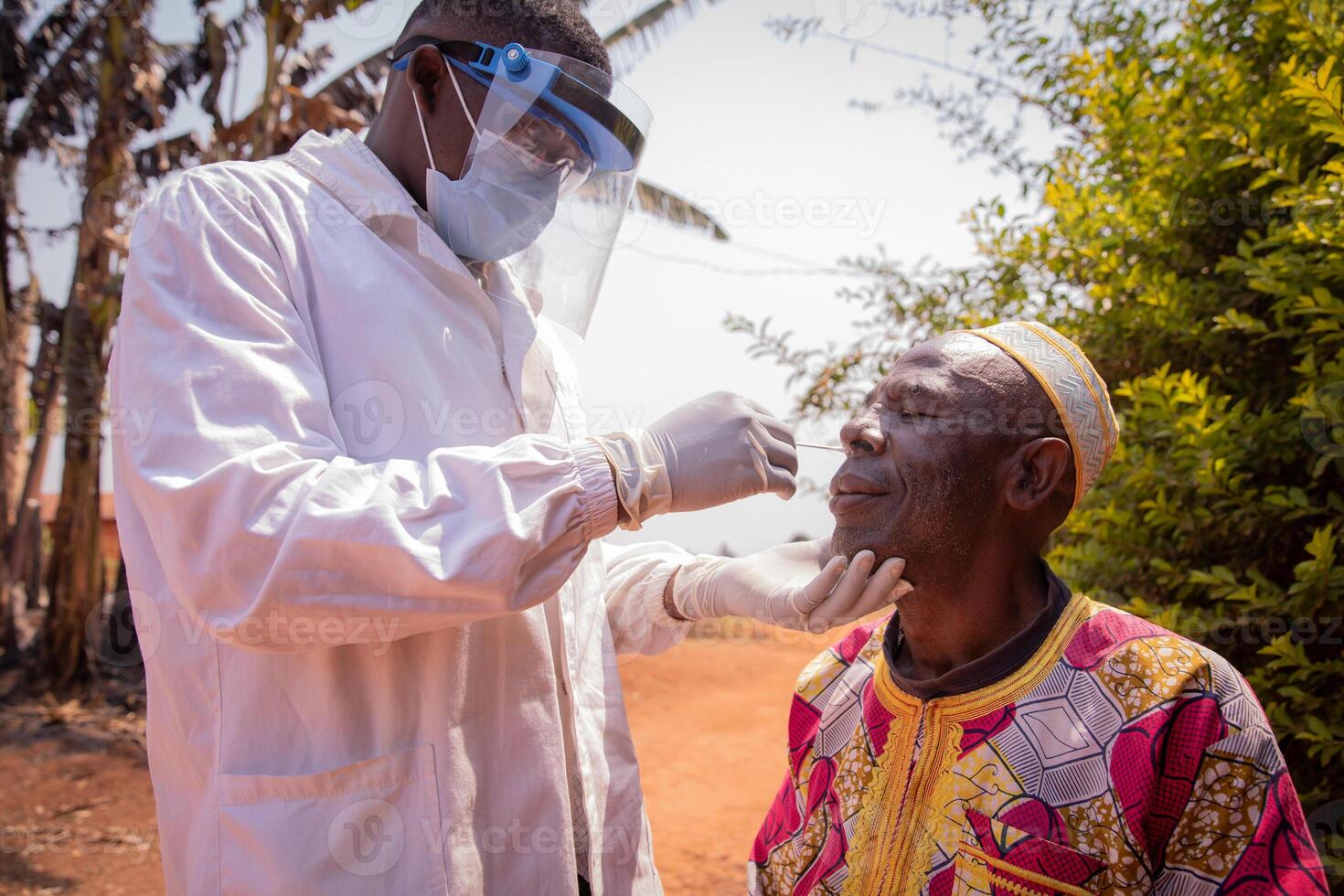 A doctor performs a coronavirus test with a swab on an elderly African patient. Covid-19 test in africa photo