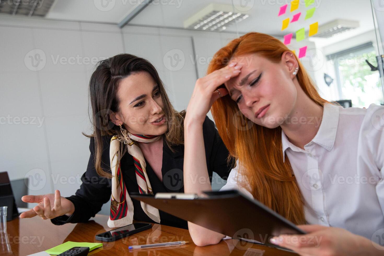 A businesswoman tries to comfort her colleague who is sad and stressed photo