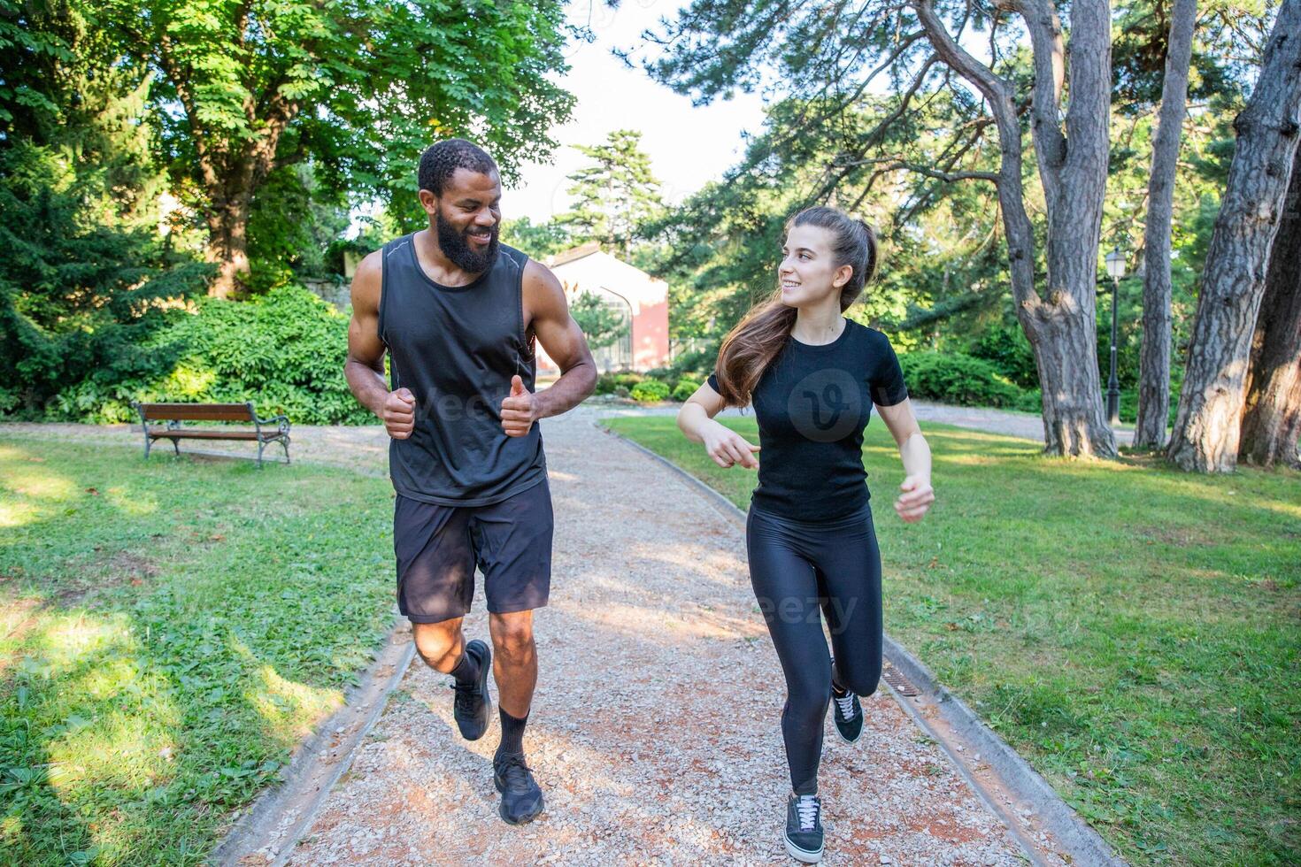 Two athletes during a run smile and look at each other, healthy living concept photo