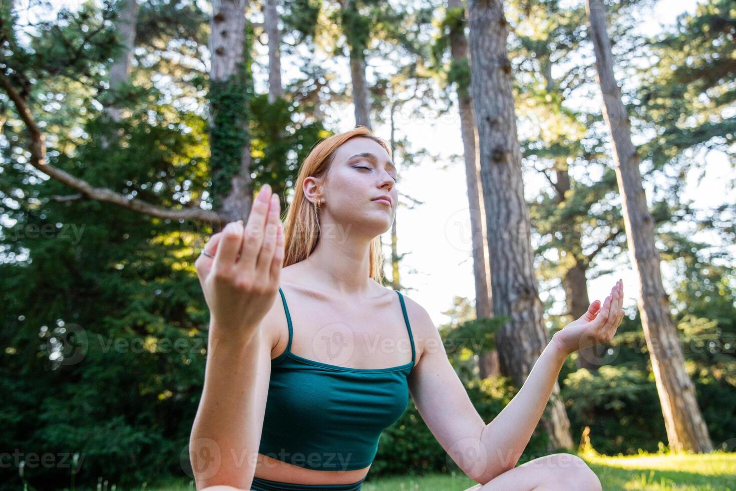 A girl during a yoga session meditates in the open air in a public park photo