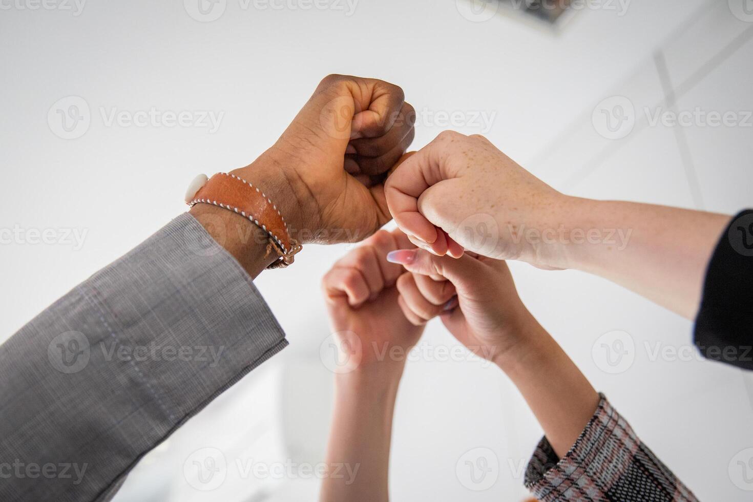 Joined fists of businesspeople of different ethnicities together photo