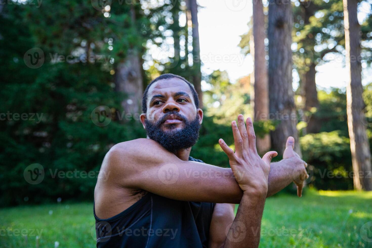 A concentrated athlete performs an arm stretch exercise to increase his flexibility photo