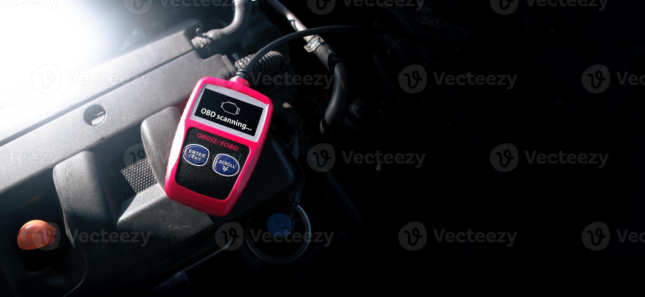 OBD2 or OBD scanner tool on car engine compartment for engine system analysis to fixing car engine system , Car maintenance service concept photo