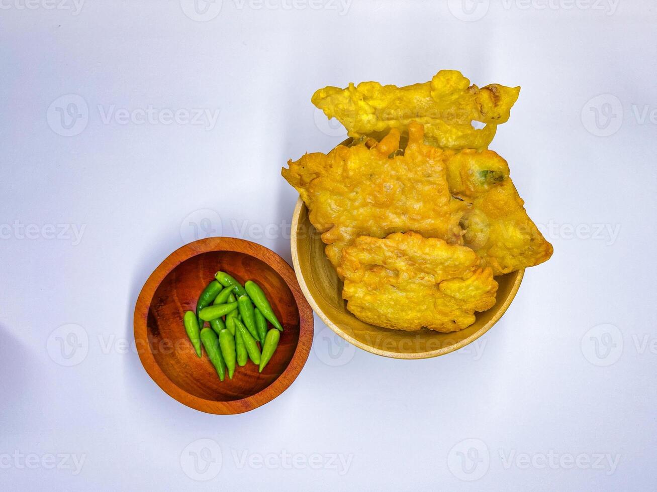 Traditional Indonesian Food Called Tempe Goreng or Mendoan or Fried Tempeh with Flour Batter served with Green Cayenne Pepper or Green Colored Chilli on Isolated White Background. High quality photo