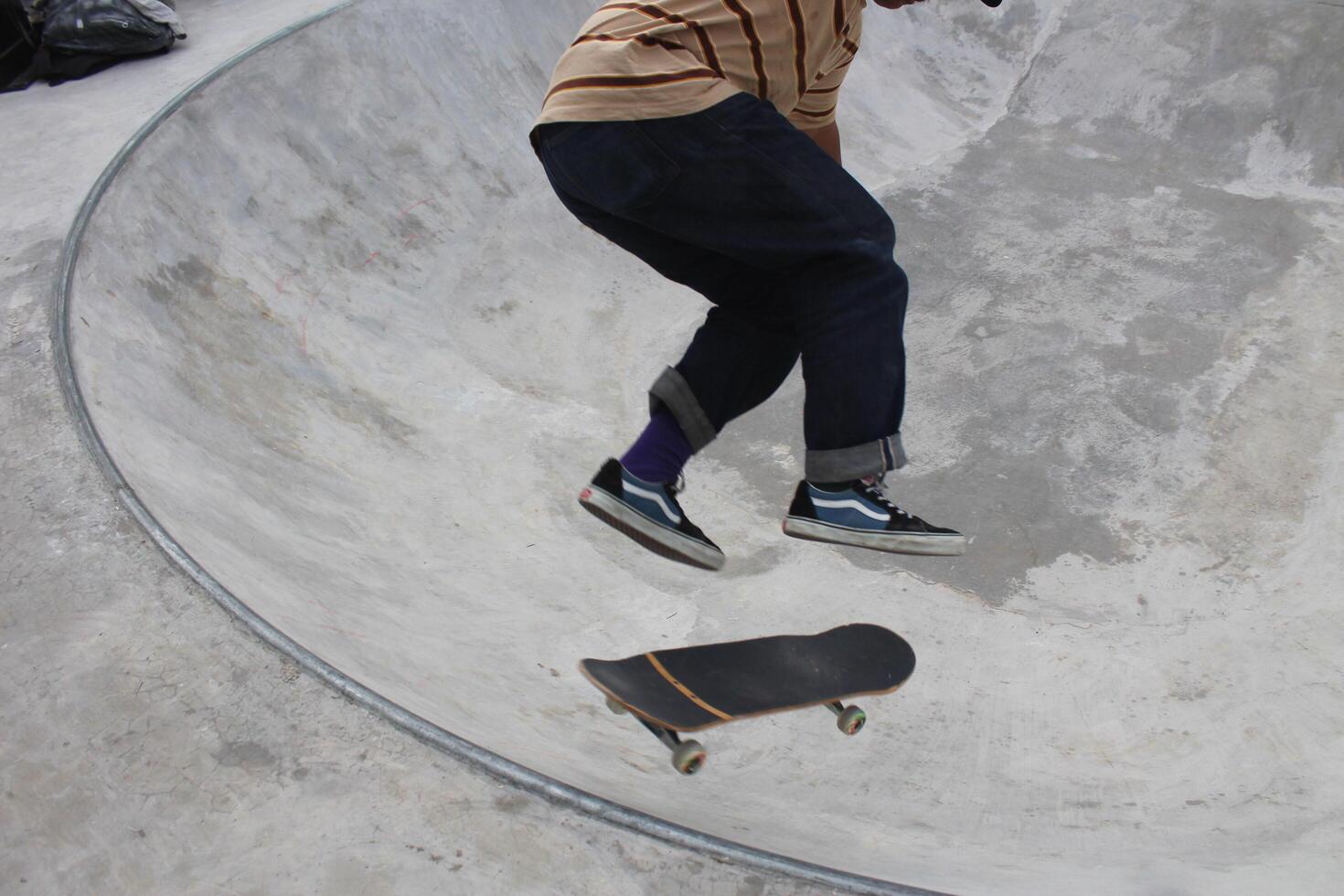 a skateboarder is doing tricks in the bowl Indonesia - Medan, 21 June 2024 photo