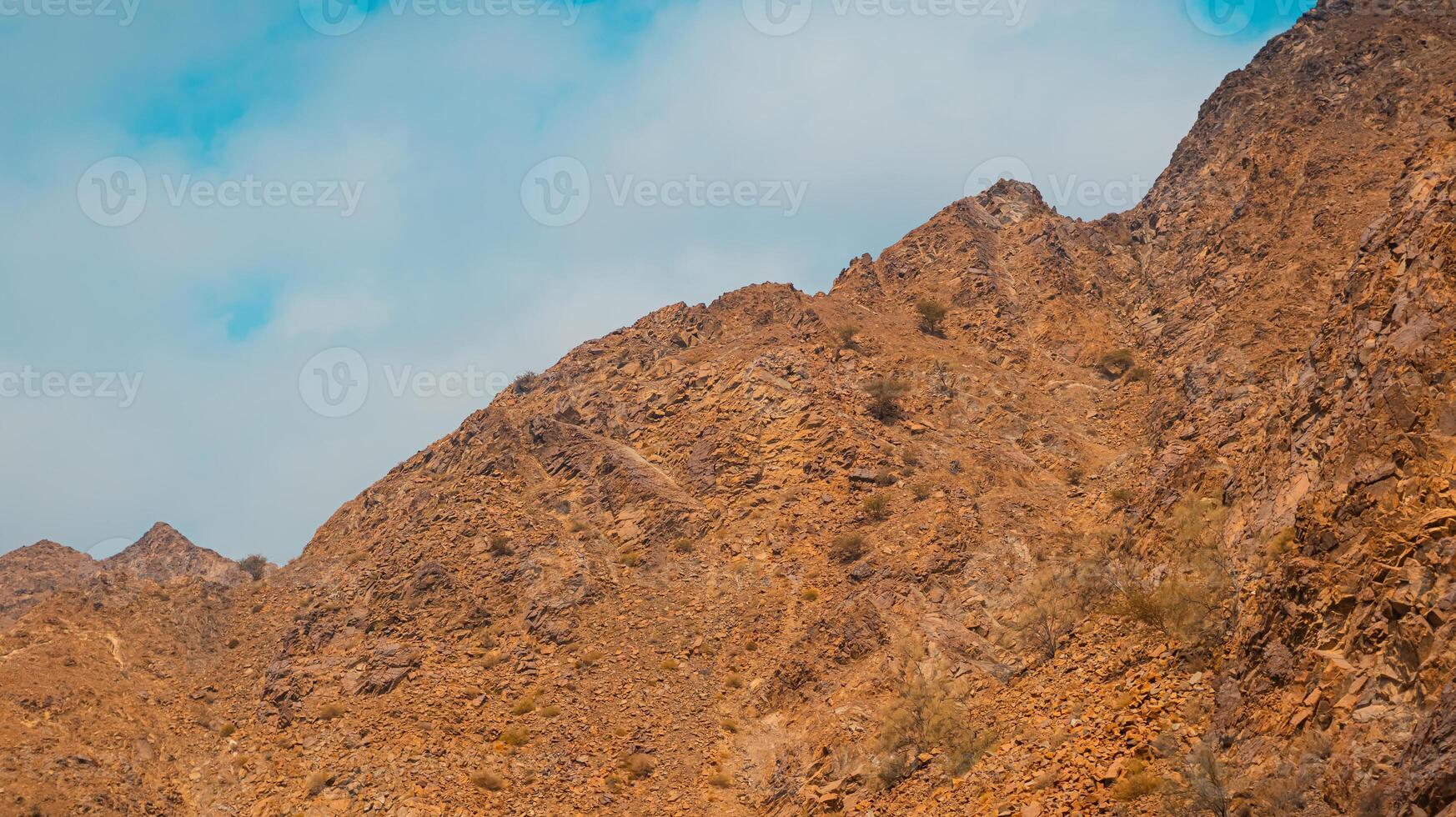 Fujairah mountains, extension of Omani Al Hajar mountain range. Cloudy winter day on empty street. photo