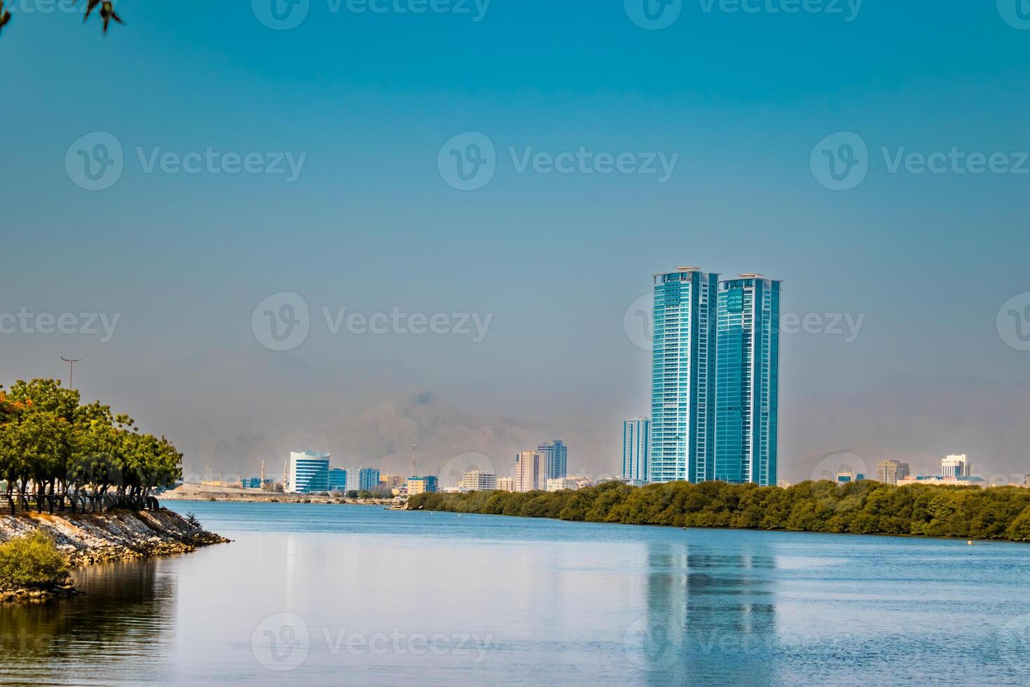 embankment of the city of Donetsk along the Kalmius river. Multi-storey buildings rise. A bridge crosses the river connecting part of the city photo