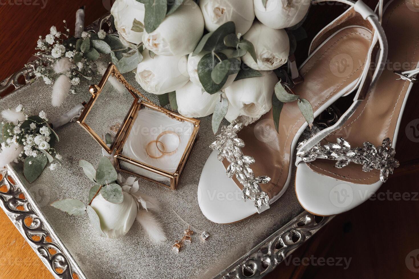 A tray with a white box and a pair of white shoes with a flower on it photo