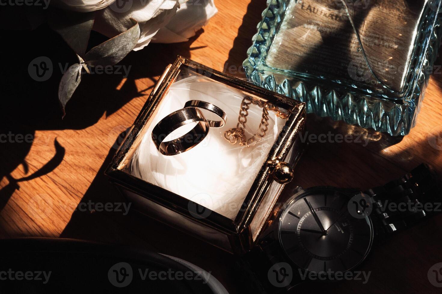 A couple's wedding rings are displayed in a glass box on a table photo