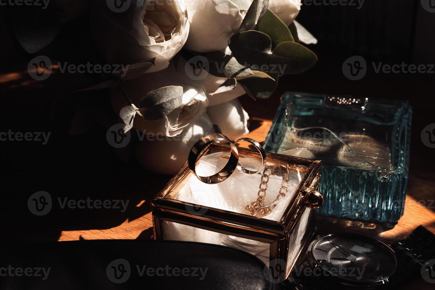 A couple of gold rings are displayed in a glass box on a table photo