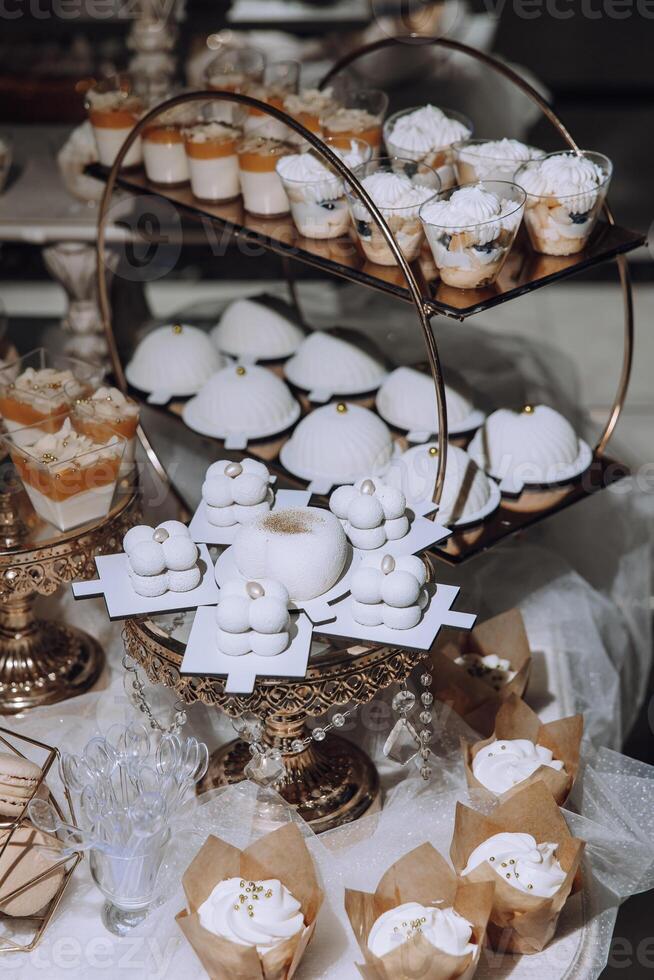 A table with a variety of desserts, including cupcakes and cakes photo