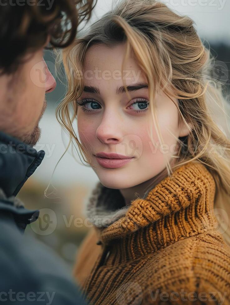 Woman in a Brown Sweater Looking at the Camera With a Man Behind Her photo