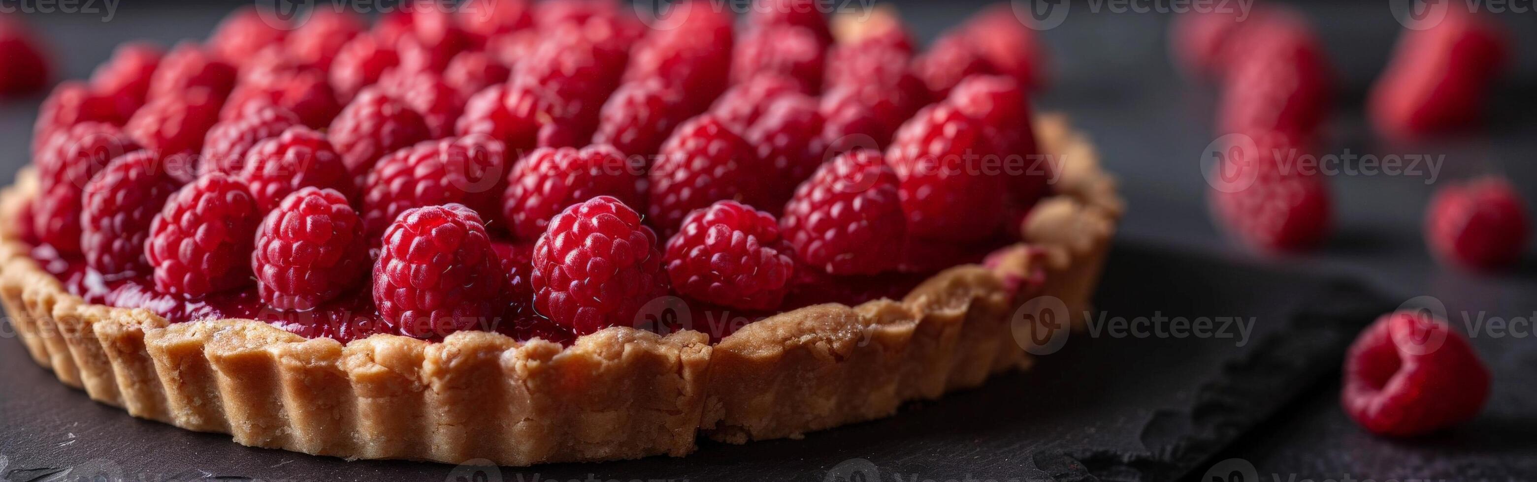 Fresh Raspberry Tart With Flaky Crust on Dark Surface photo