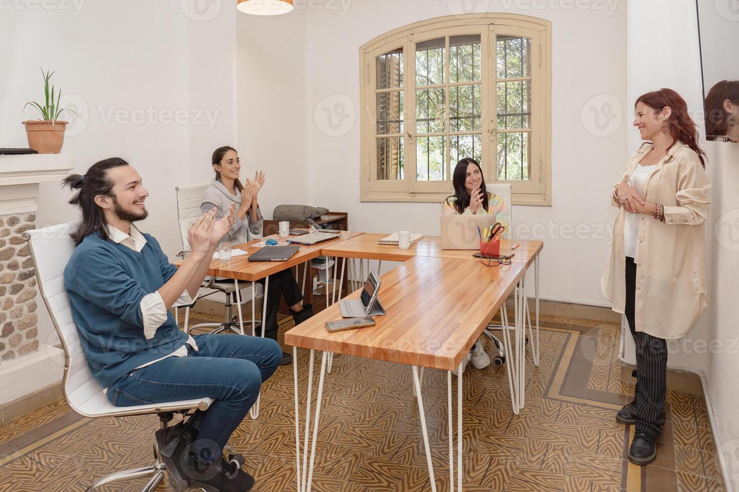 Team of colleagues applauding a presentation in a modern office environment. photo