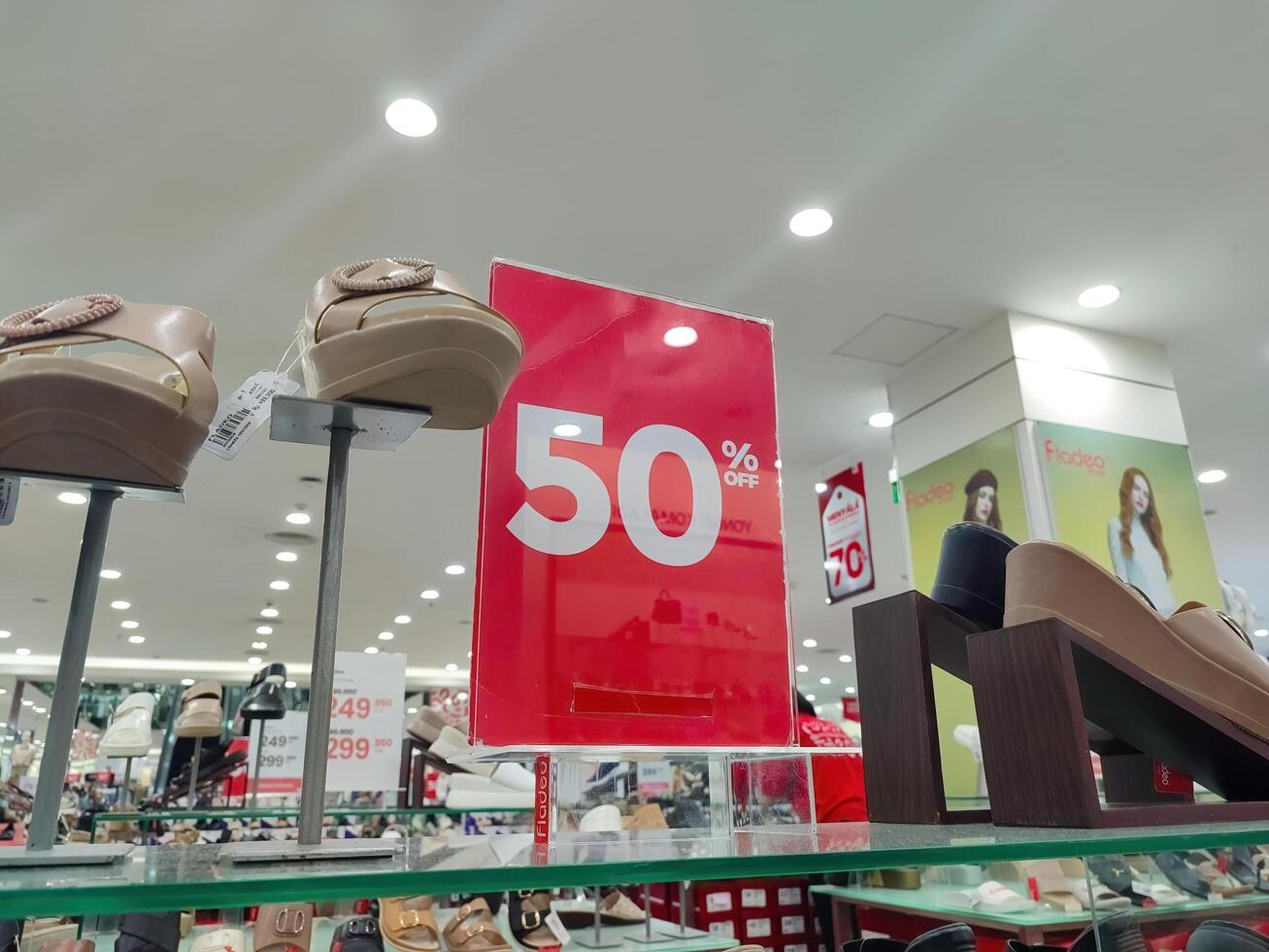a board that says fifty percent discount in red in a clothing store or department store, Indonesia, 28 May 2024. photo