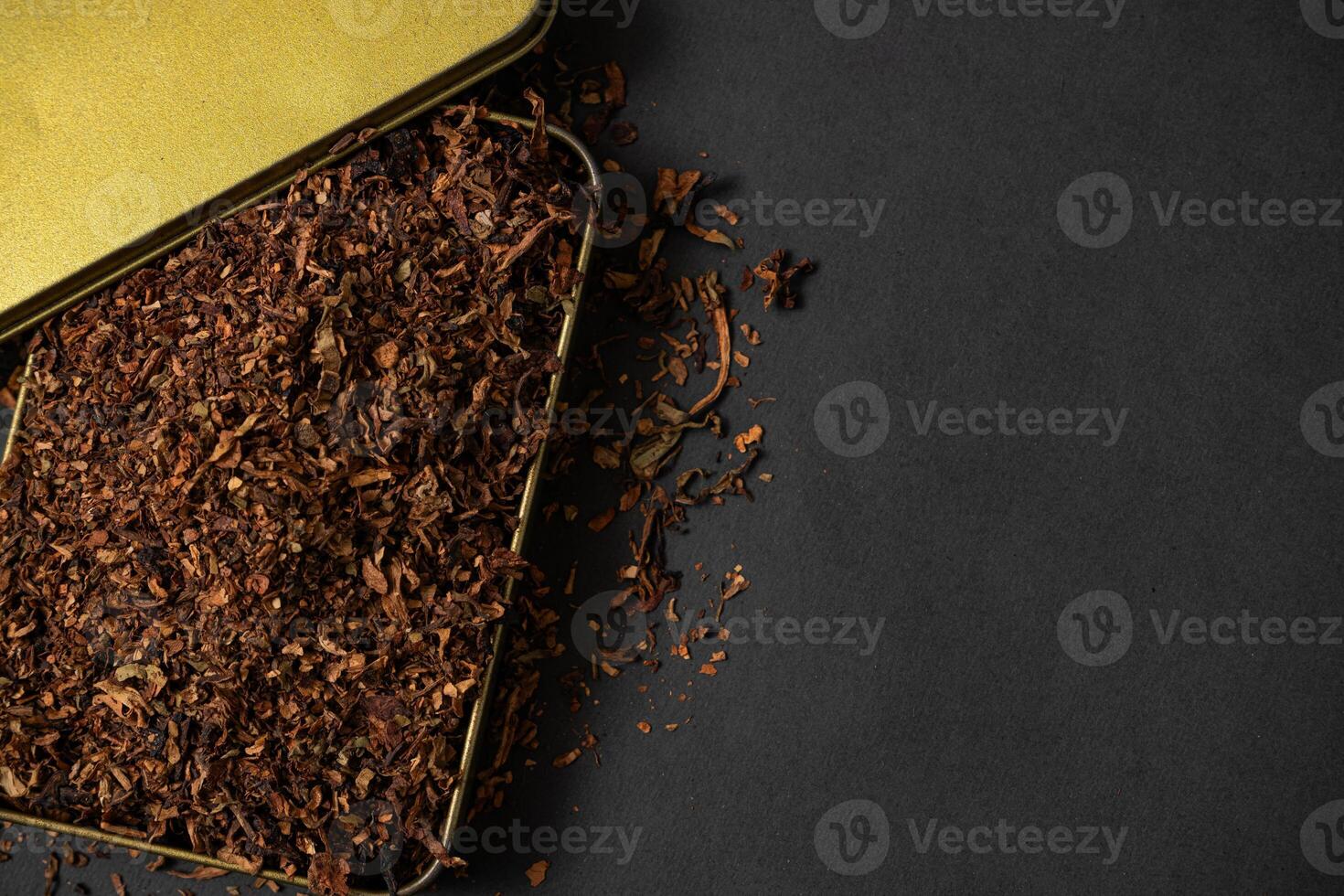 fine tobacco in a gold iron box on a black table photo
