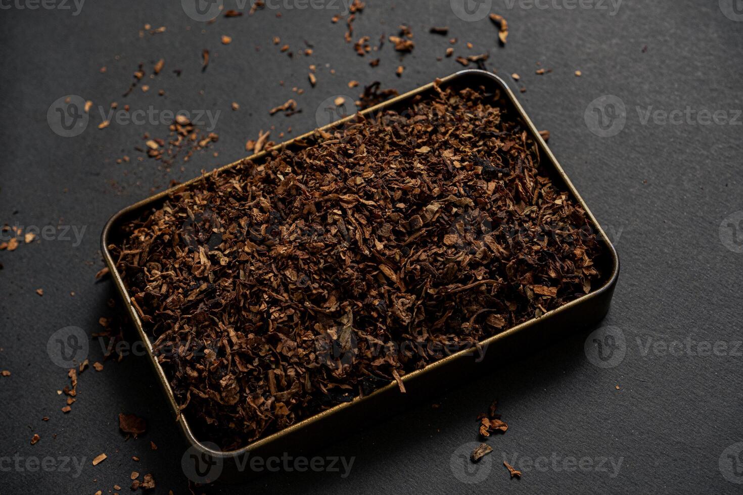 fine tobacco in a gold iron box on a black table photo