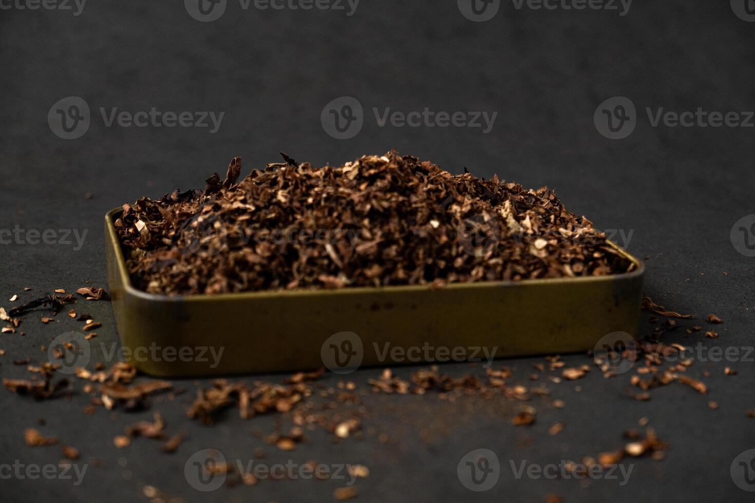 fine tobacco in a gold iron box on a black table photo