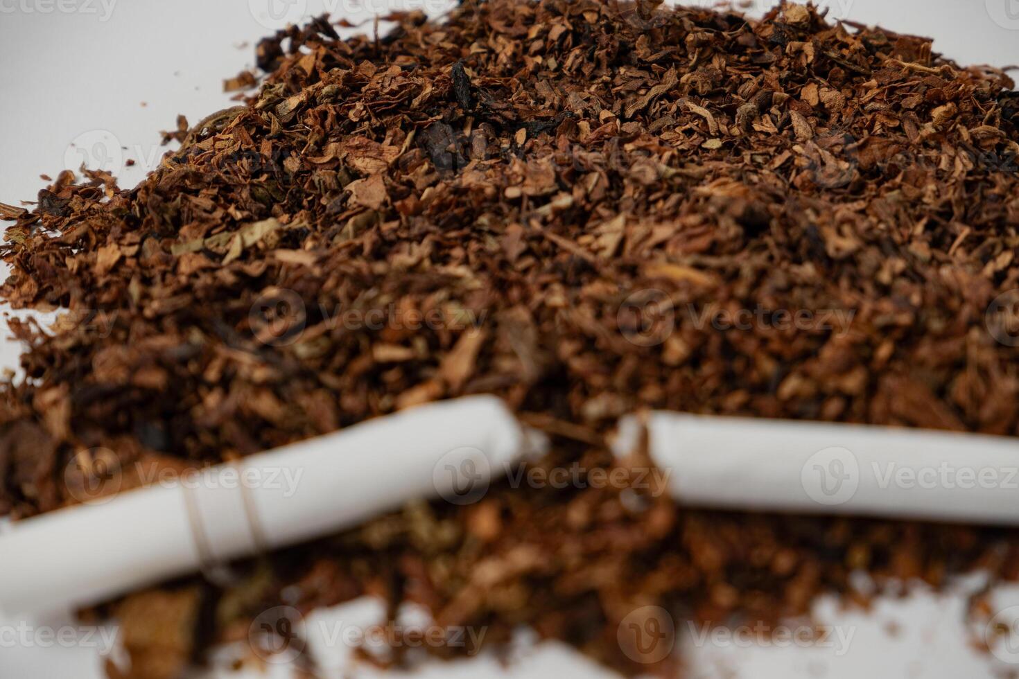 a broken cigarette over fine tobacco photo