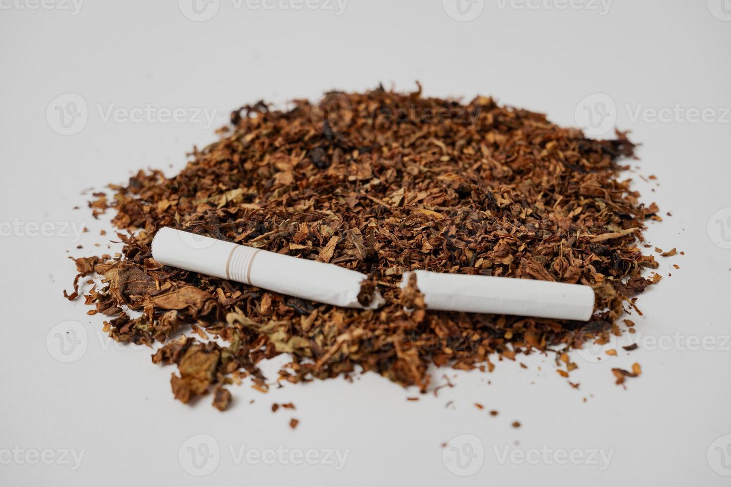 a broken cigarette over fine tobacco photo