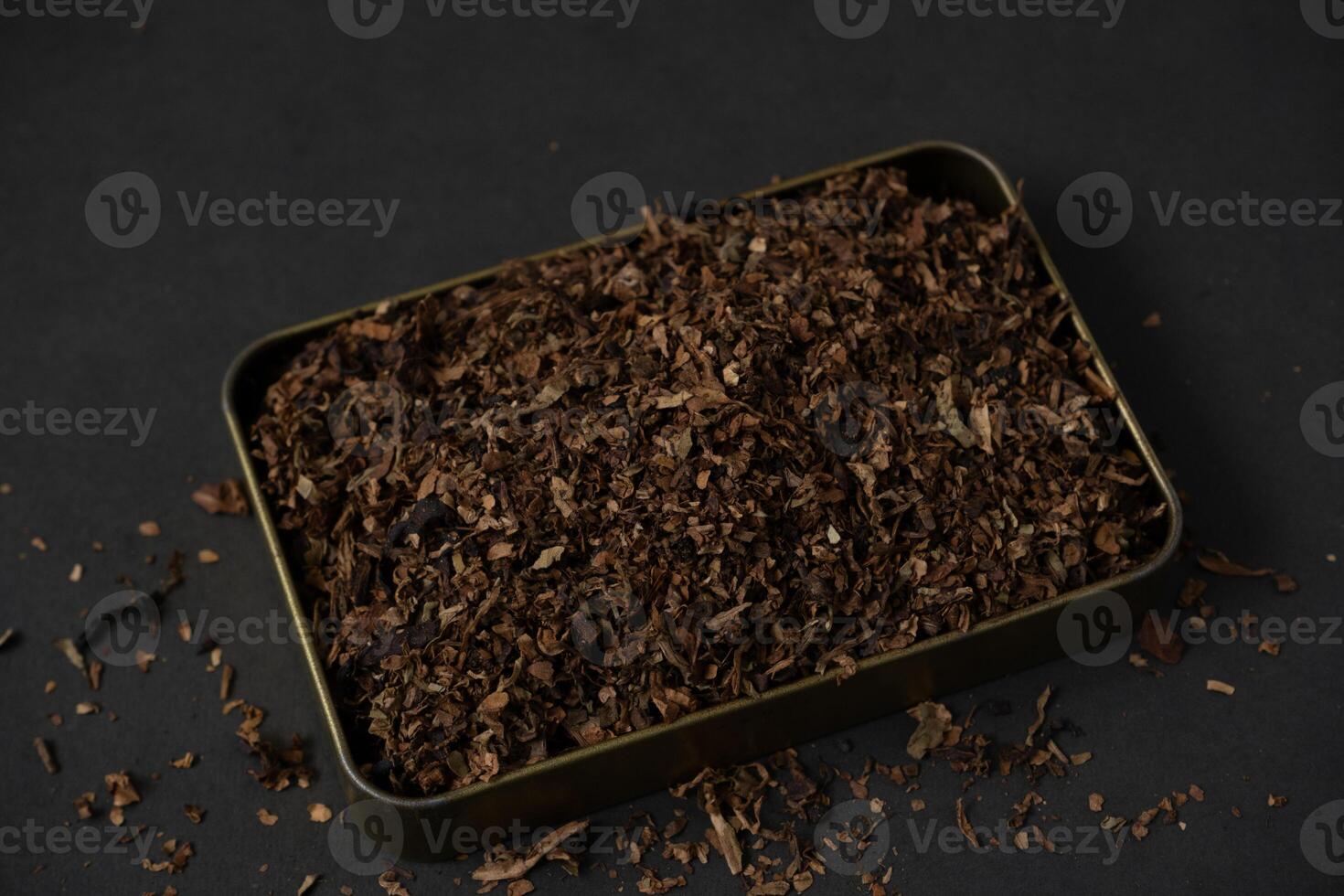 fine tobacco in a gold iron box on a black table photo