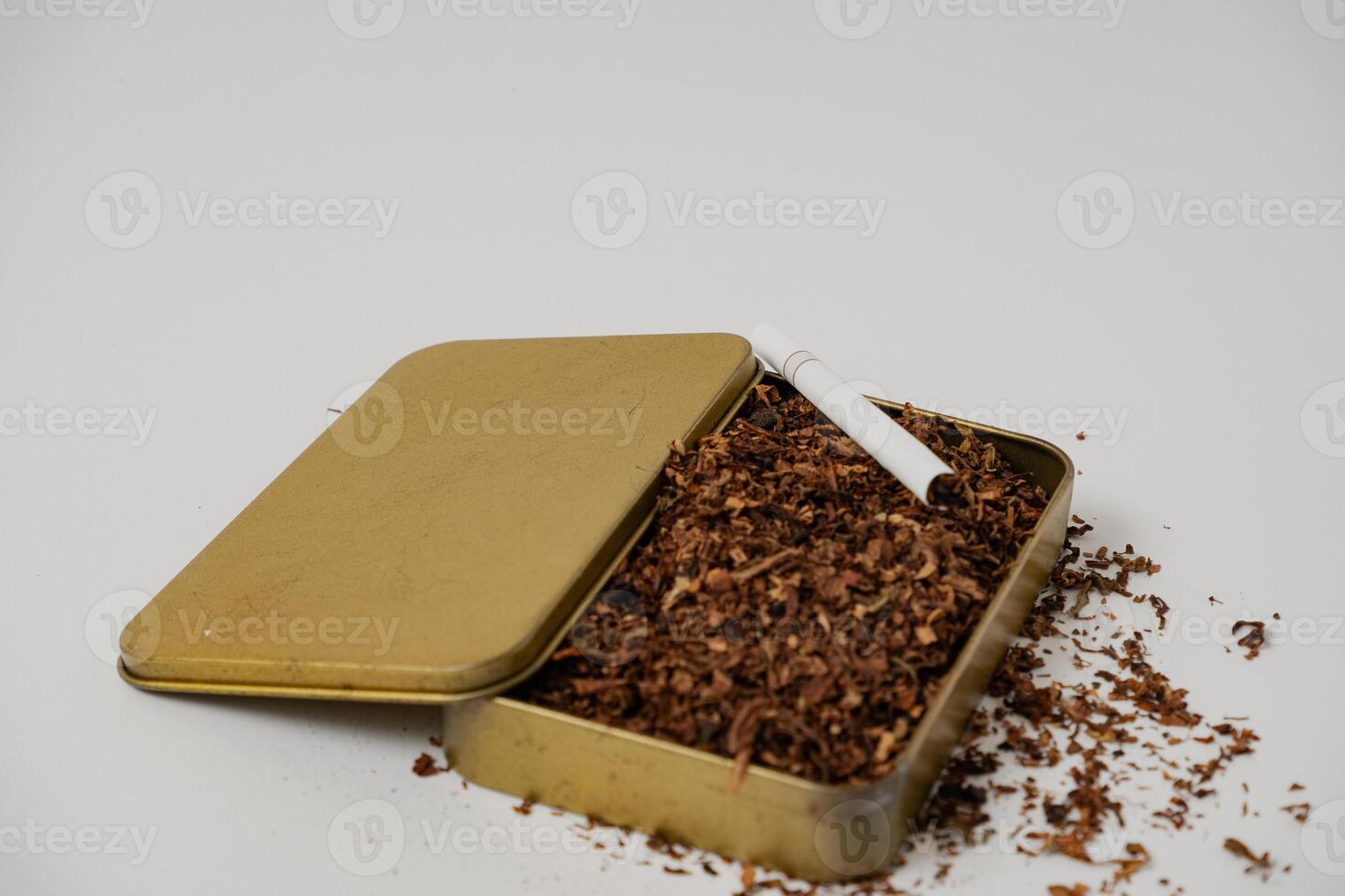 tobacco and some cigarettes around it with a white background photo