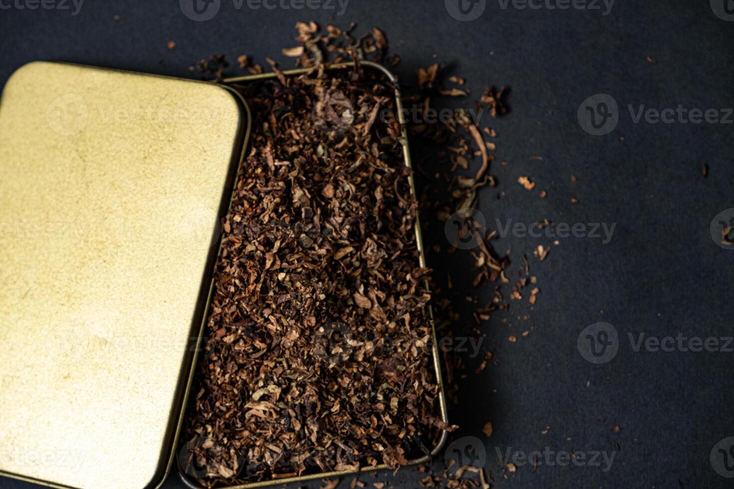 fine tobacco in a gold iron box on a black table photo