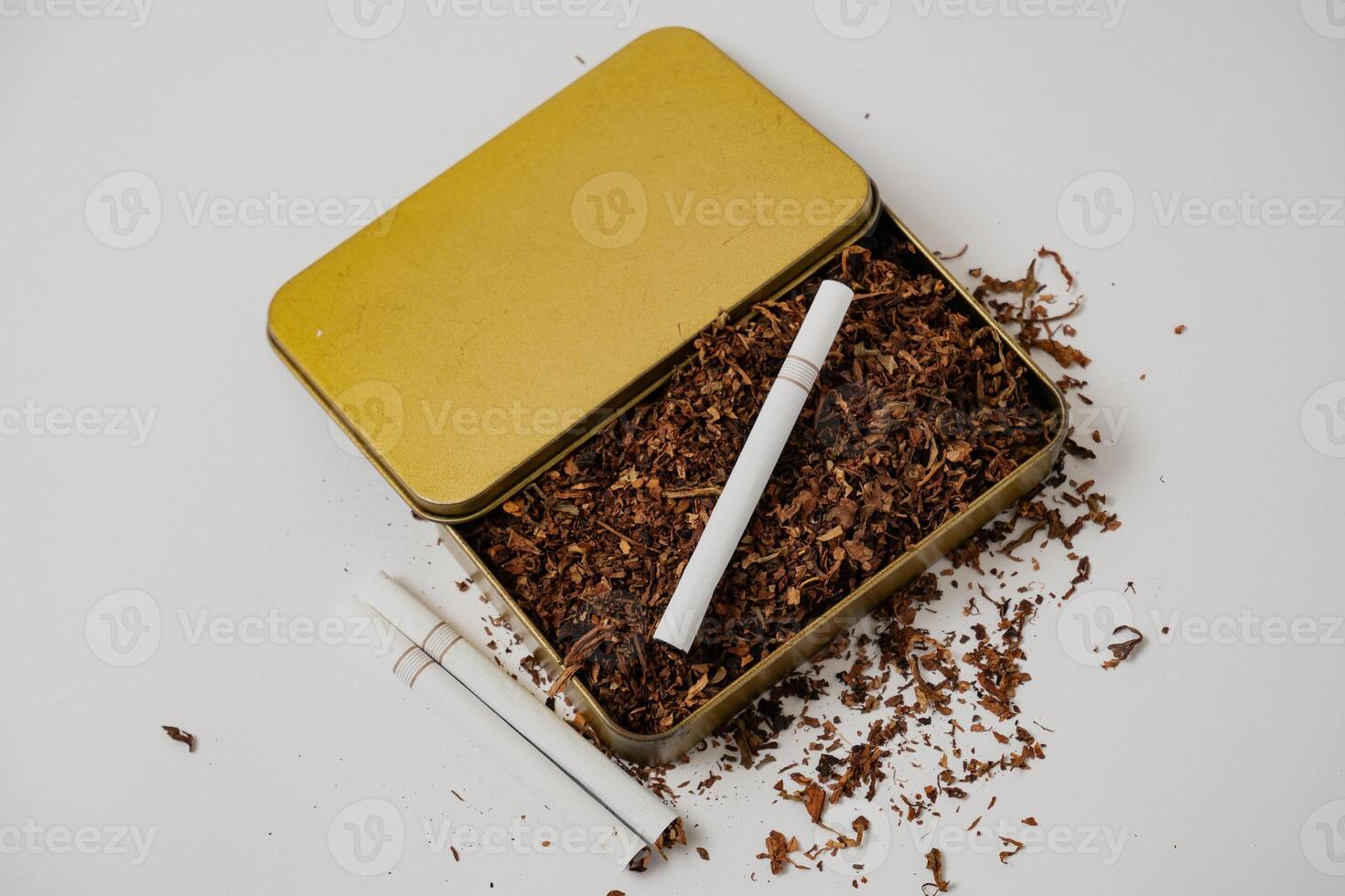 tobacco and some cigarette around it with a white background photo